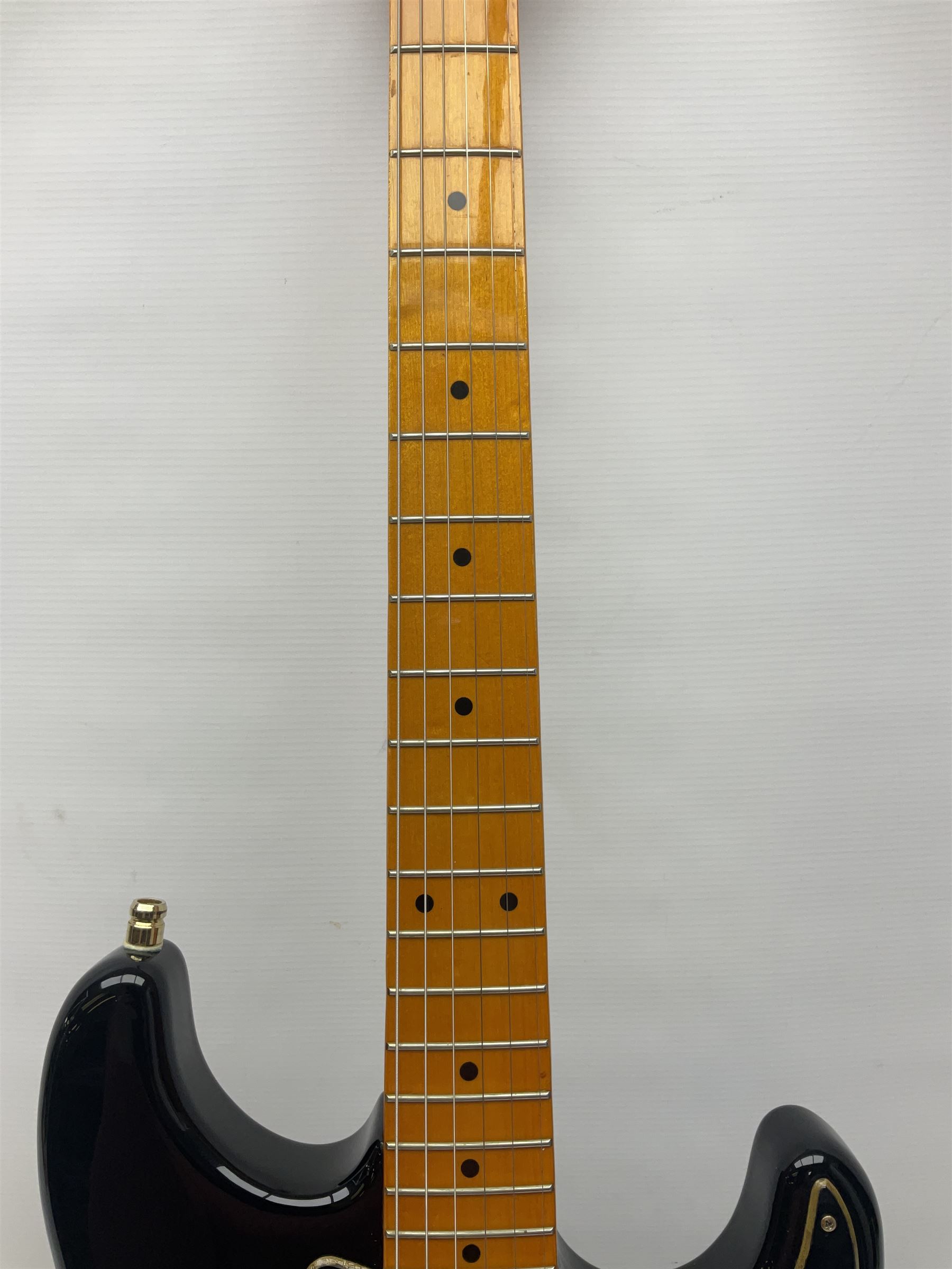 Copy of a Fender Stratocaster electric guitar in black with Wilkinson bridge, lock-in tuners, synchronised tremolo and various patent numbers; L99cm; in hard carrying case with strap and digital tuner