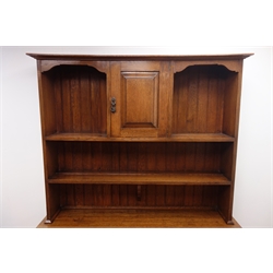  Early 20th century oak Arts & Crafts dresser, projecting cornice above panelled cupboard and two tier plate rack, panelled double cupboard, cabriole supports, W139cm, H190cm, D51cm  