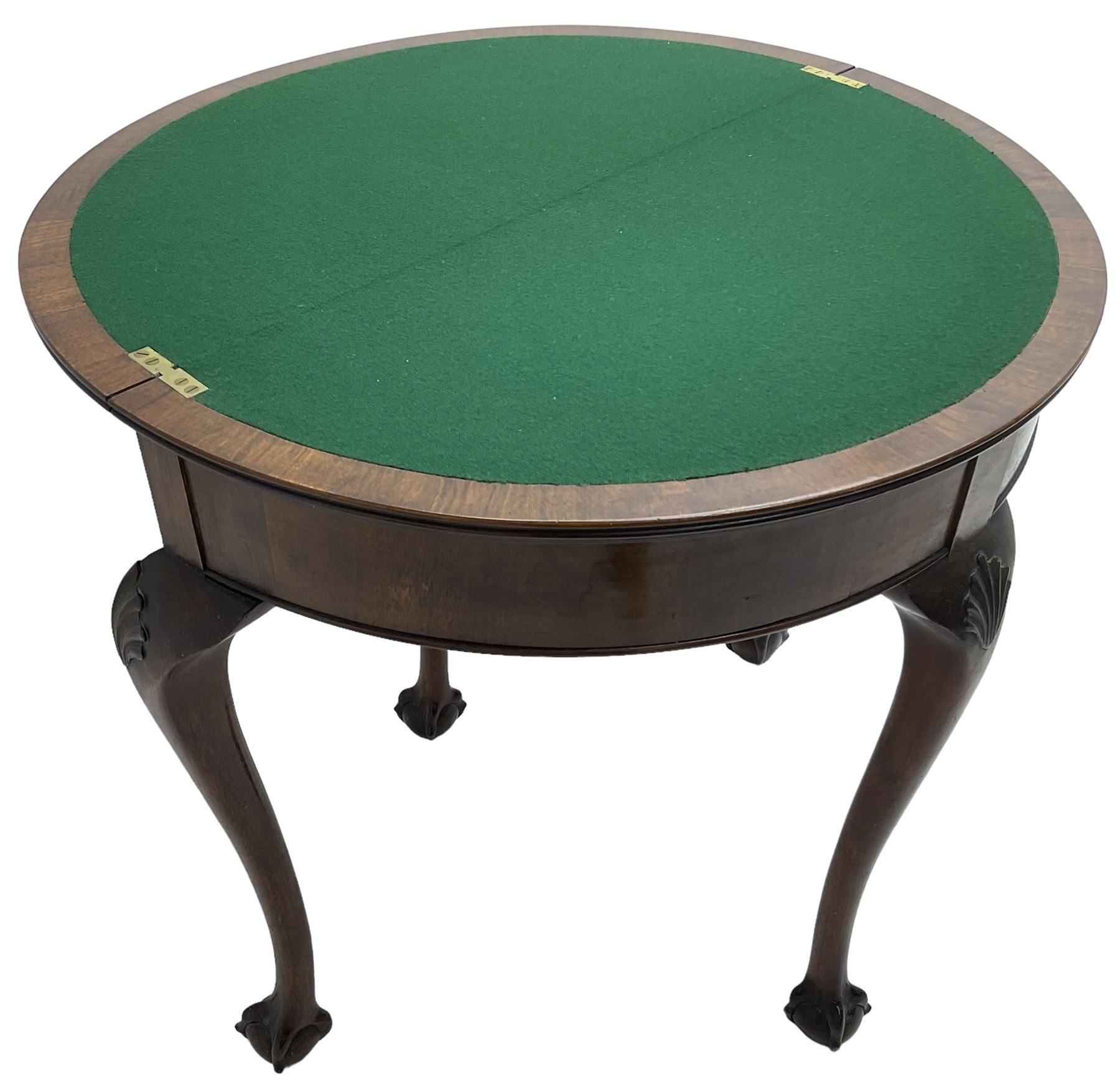 Early 20th century figured walnut demi-lune card table, fold-over reed moulded top with baize lined interior, pull-out rear support with storage well, on shell carved cabriole supports with ball and claw feet