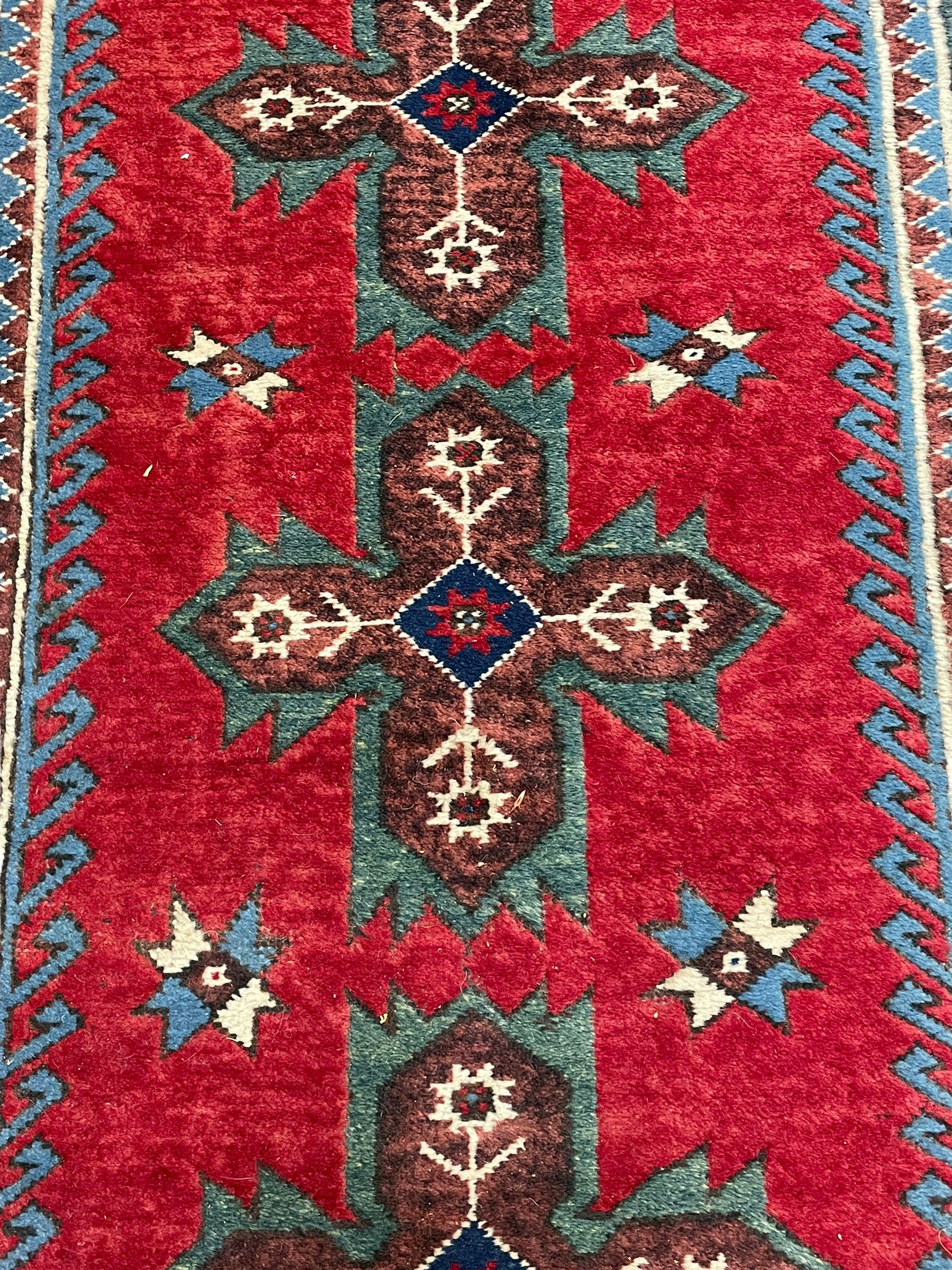 Turkish red ground runner, seven star and leaf decorated medallions, geometric design repeating border