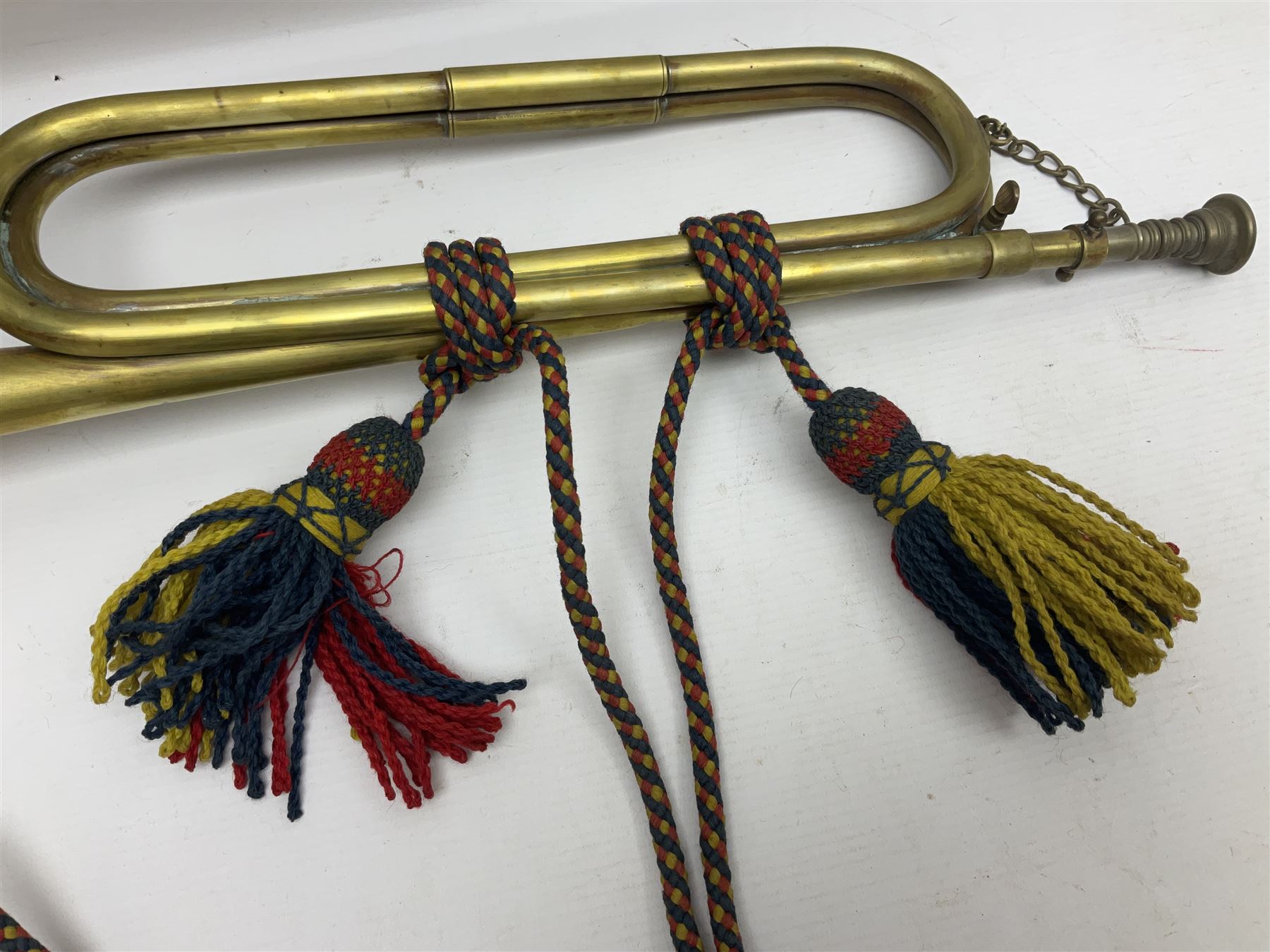 Two military brass bugles by Mayers and Harrison Ltd. Manchester each with crows foot mark and dated 1966; both with multi-coloured cord and tassels, longest 52.5cm (2)