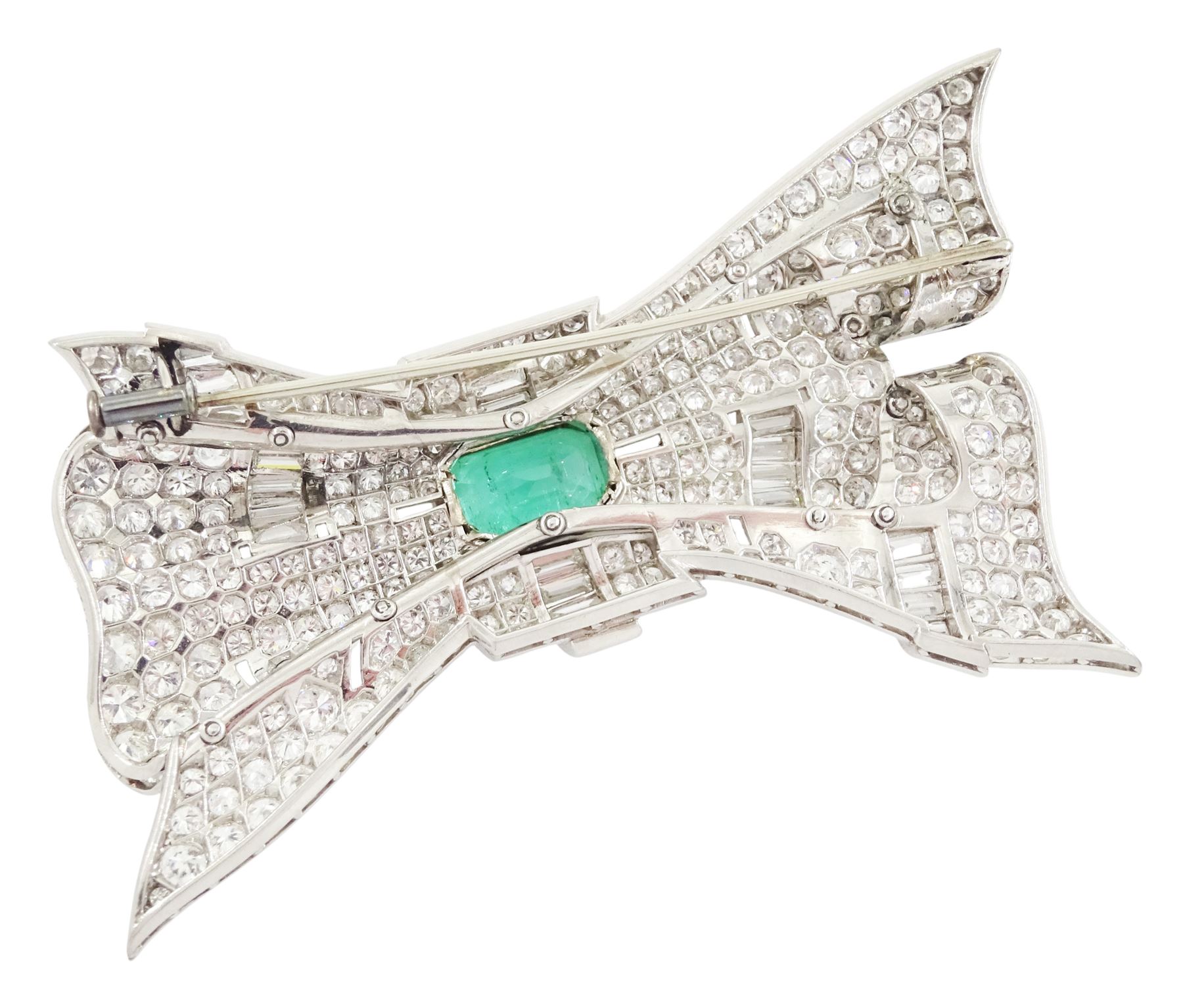 Platinum emerald and diamond bow brooch, central octagonal cut emerald of approx 4.00 carat, with round brilliant and baguette cut diamond surround, total diamond weight approx 23.00 carat