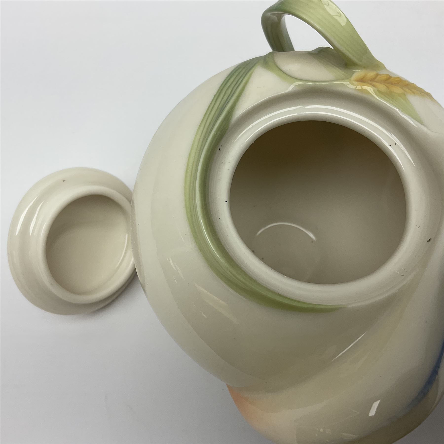 Franz Teapot decorated with dragonflies, together with a matching sucrier and cover and a cup and saucer in Iris pattern, all with printed mark beneath 