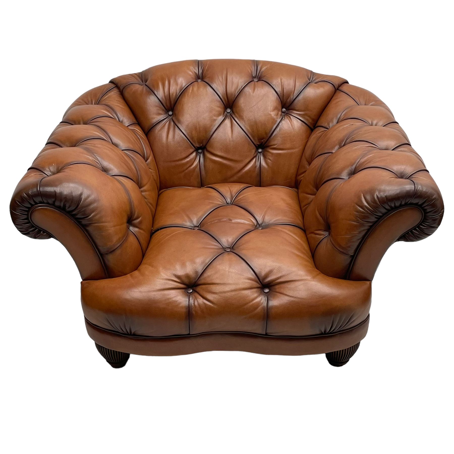 Tetrad - 'Oskar' armchair, Chesterfield shape with rolled arms, upholstered in buttoned tan leather, on turned and reed moulded feet 