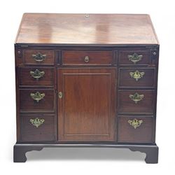 George III mahogany bureau, the fall-front enclosing fitted interior with pigeonholes and central cupboard, over an arrangement of nine short drawers surrounding a central cupboard, on shaped bracket feet
