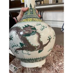 Pair 20th century Chinese famille verte bottle vases, each decorated with green and purple dragons chasing pearls amidst auspicious flames, the neck with yellow and green stylised foliate and cell borders, and the white glazed body incised throughout with fan shapes, each with red character mark beneath flanked by green dragons, H38cm

