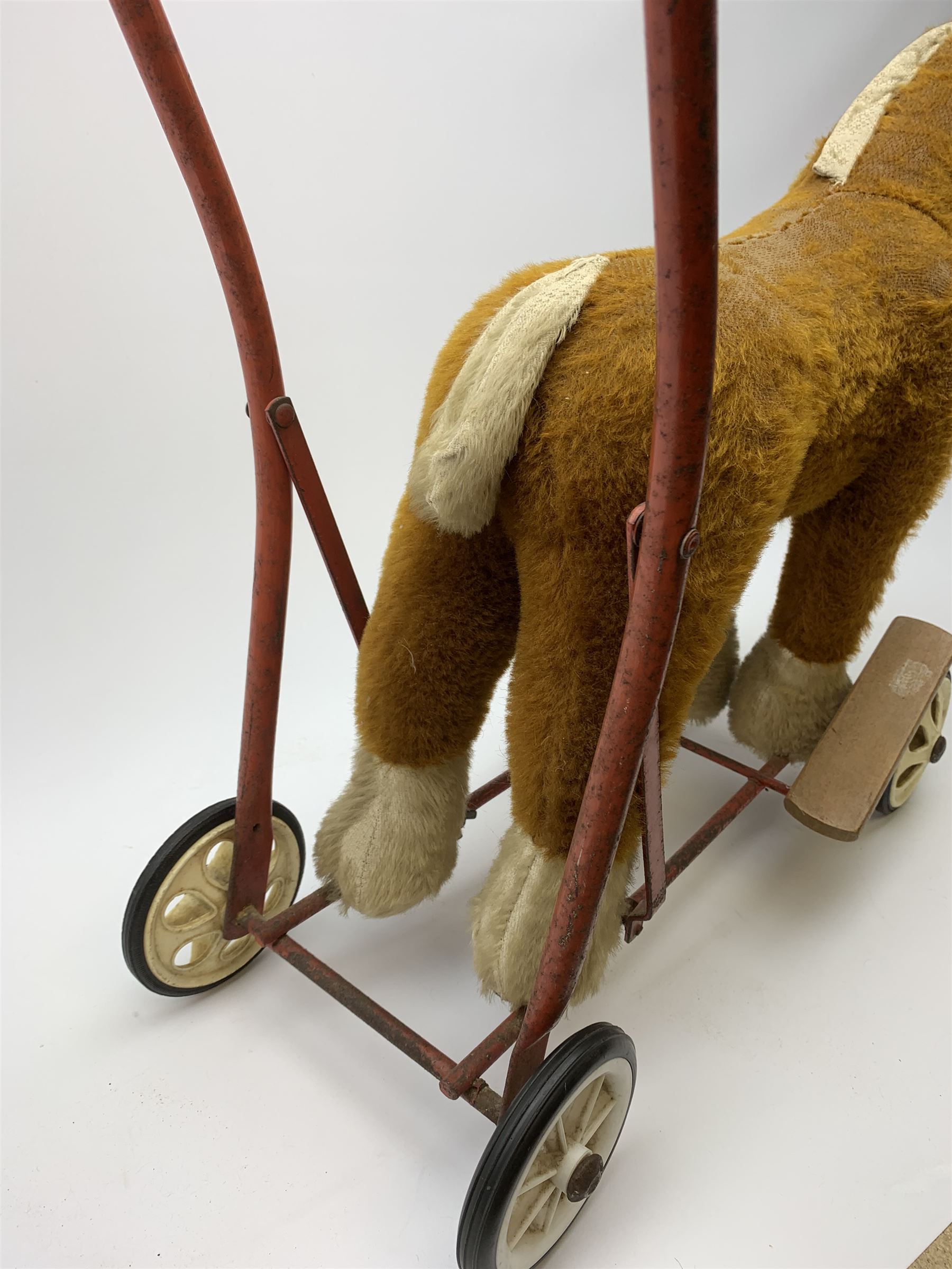 Pedigree push along plush covered horse 1950s-60s with red tubular metal framework and beech foot rests H25