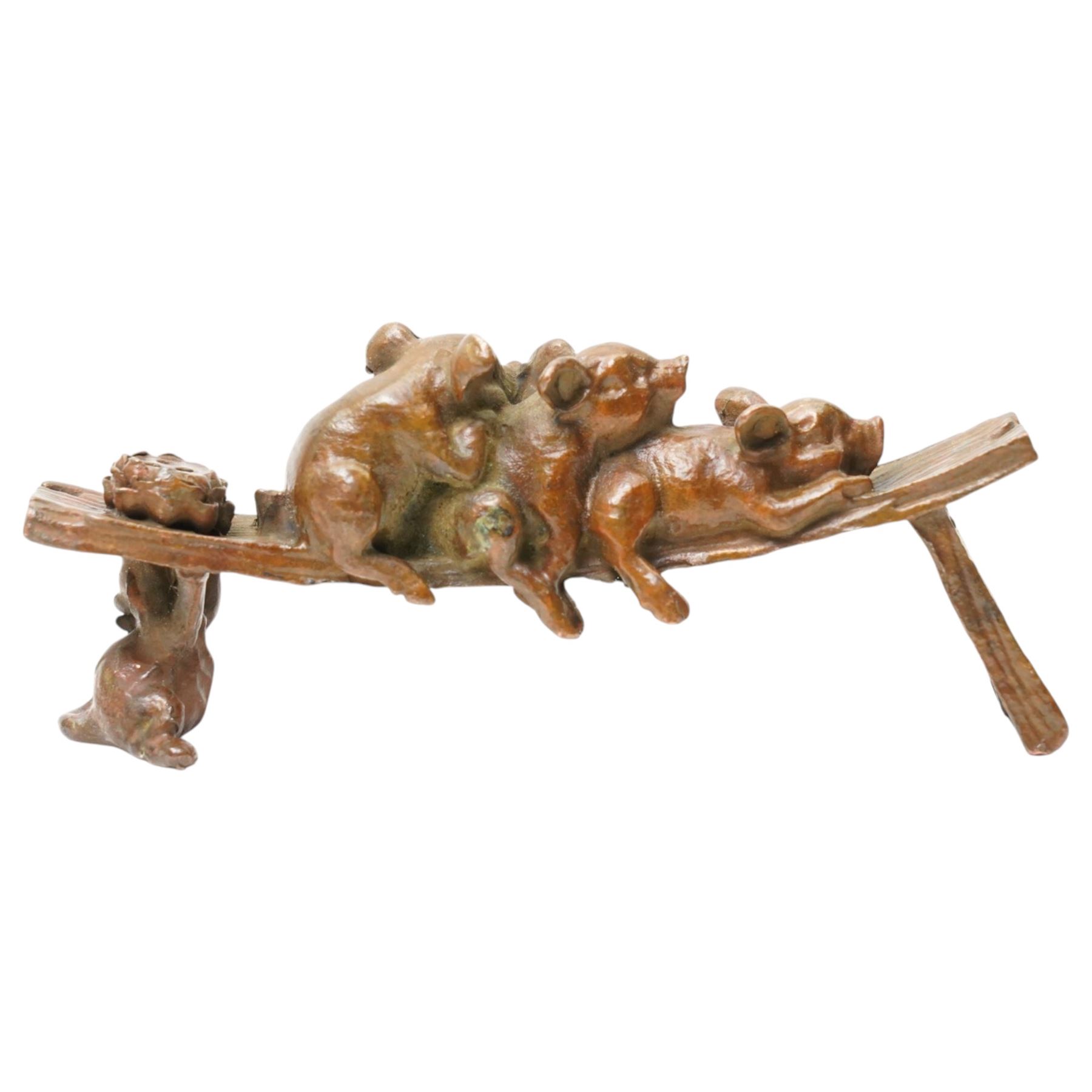Bronze figure of three pigs resting on a bench, W10cm 