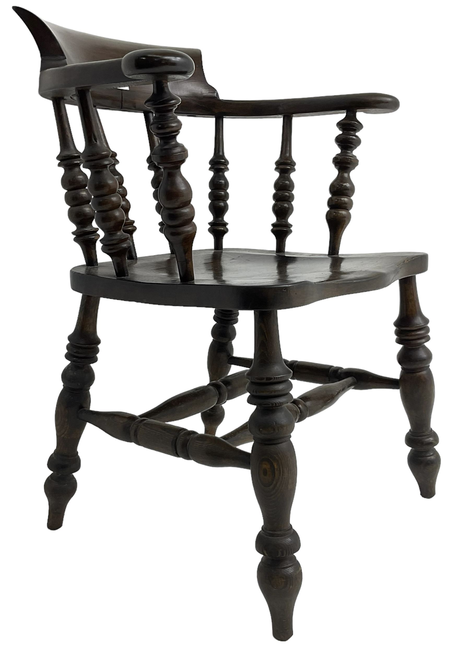 Early 20th century stained beech captains smokers bow chair, spindle tub shaped back over saddle seat, raised on turned supports united by double H-stretcher