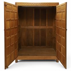 Mouseman - early-to-mid-20th century panelled and adzed double wardrobe, the arcade carved cresting rail over two panelled doors, with wrought metal hinges and latch, deep relief carved mouse signature, the interior fitted with hanging rail, by the workshop of Robert Thompson of Kilburn