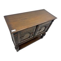 Jacobean design carved oak two door cupboard, the frieze and twin cupboard doors carved with arcaded panels and stylised foliage, raised on baluster supports united by an undertier