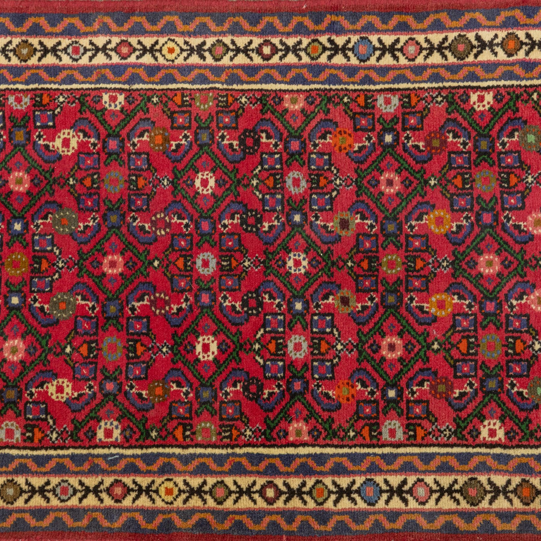 North West Persian runner, red field decorated with repeating herati motifs and small flowerheads, enclosed by cream main border with stylised floral motifs and narrow guard borders, fringed ends