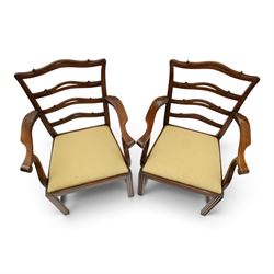 Pair of Georgian design Chippendale style mahogany elbow chairs, the pierced and waived ribbon ladder-back over scrolled arm terminals and yellow drop-in seats, on moulded and chamfered square supports