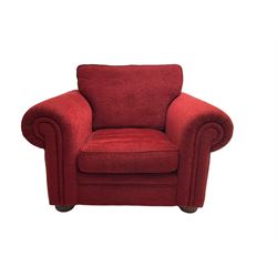 Traditional armchair upholstered in textured red fabric with matching cushions, on compressed bun feet