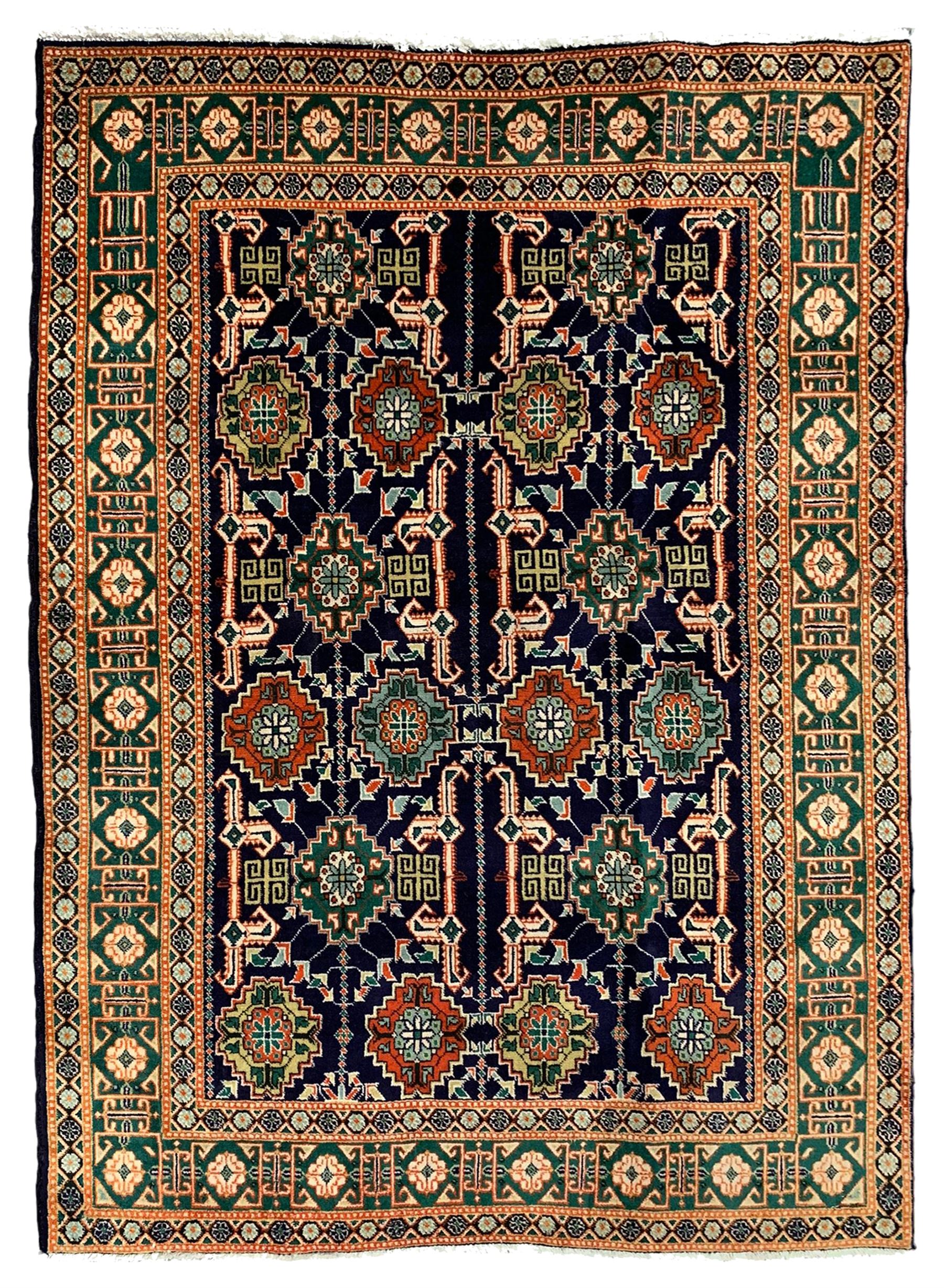 Small Persian indigo ground rug, the field decorated with Gilt motifs with trailing bead and stylised foliage, emerald green ground border decorated with geometric design and flower heads