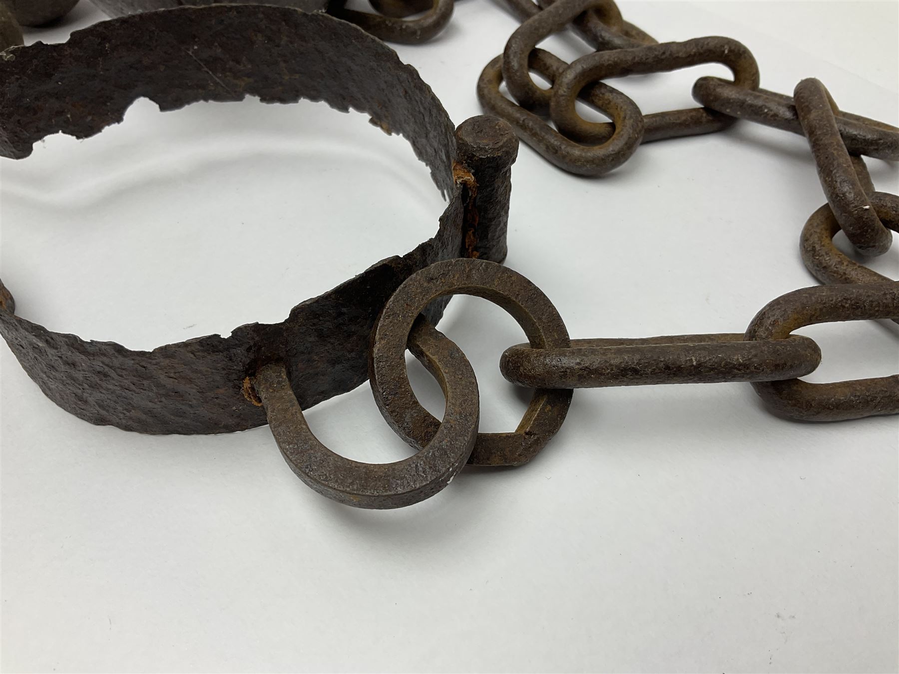 Late 19th/early 20th century prisoners iron ball and chain, with leg manacle; small cannon ball and grape shot
