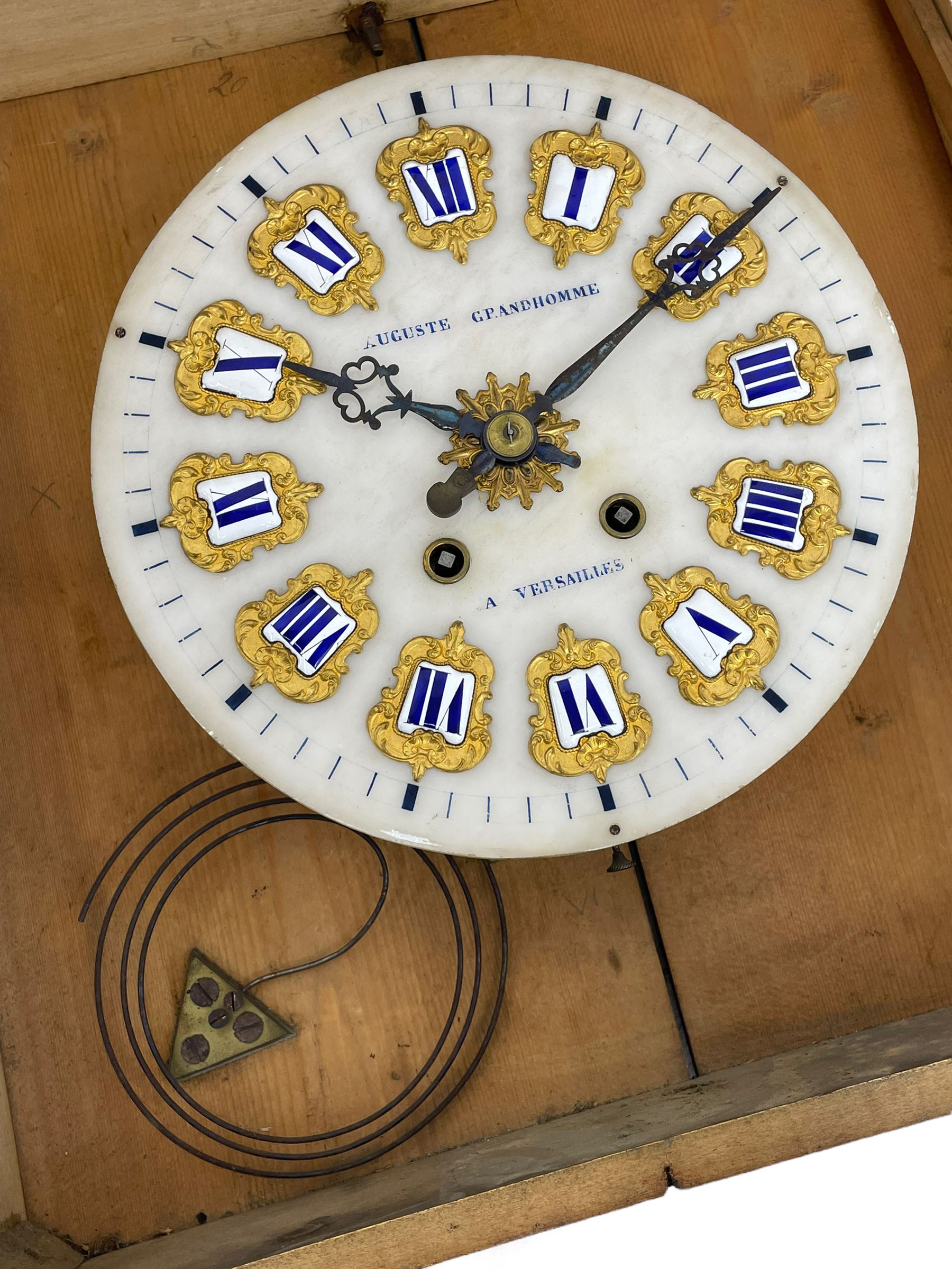 Auguste GP. Andhomme - French vineyard clock,  late 19th century 8-day twin train spring driven wall clock with enamelled and inlaid brass decoration within an ebonised and glazed case, circular enamel dial with cartouche Roman numerals, minute markers, pieced steel hands and a chased brass slip, striking movement, sounding the hours and half hours on a coiled gong. With pendulum and key.  
