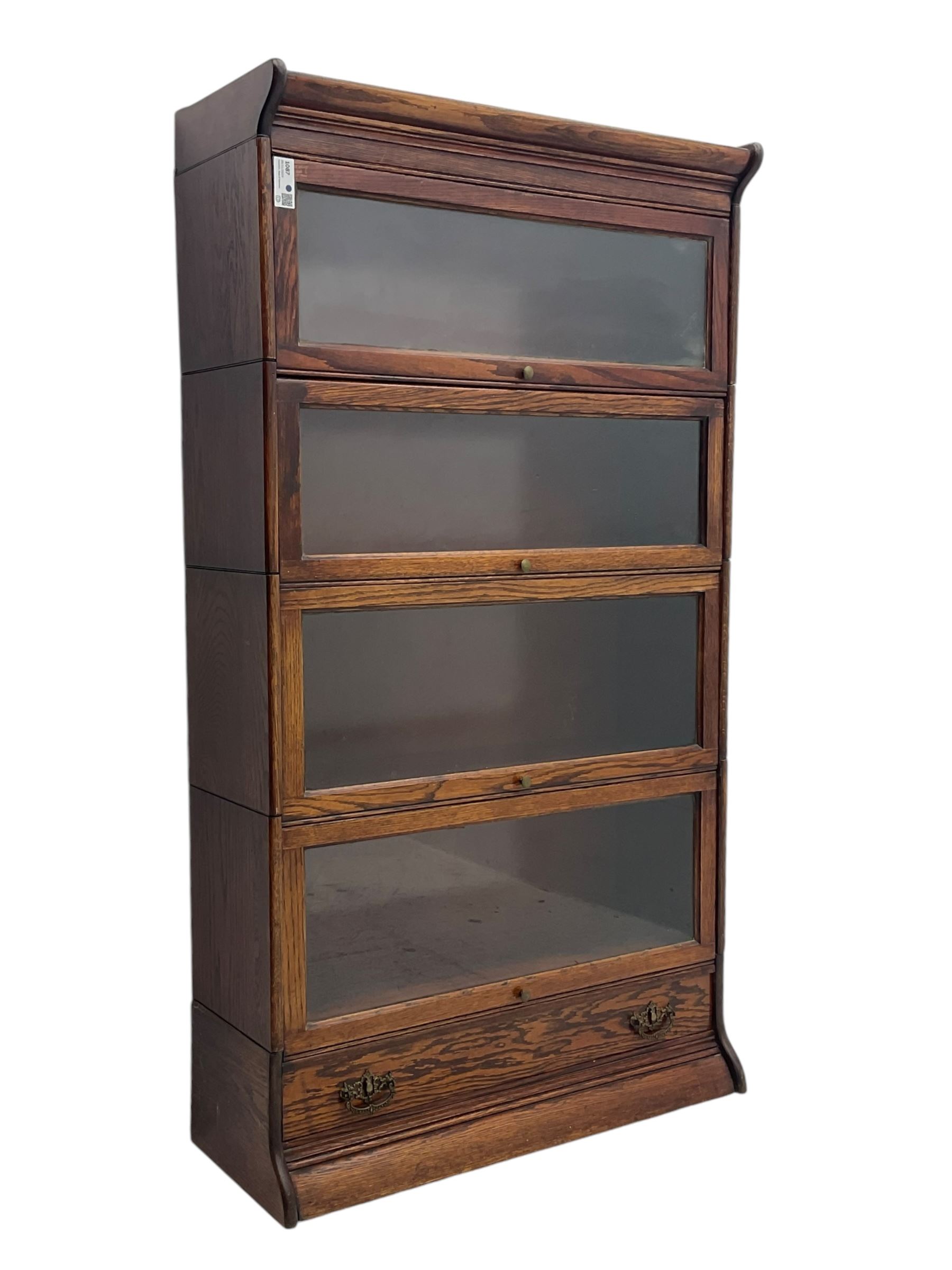 Early 20th century oak stacking library bookcase, four sections enclosed by hinged and sliding glazed doors, fitted with single drawer 