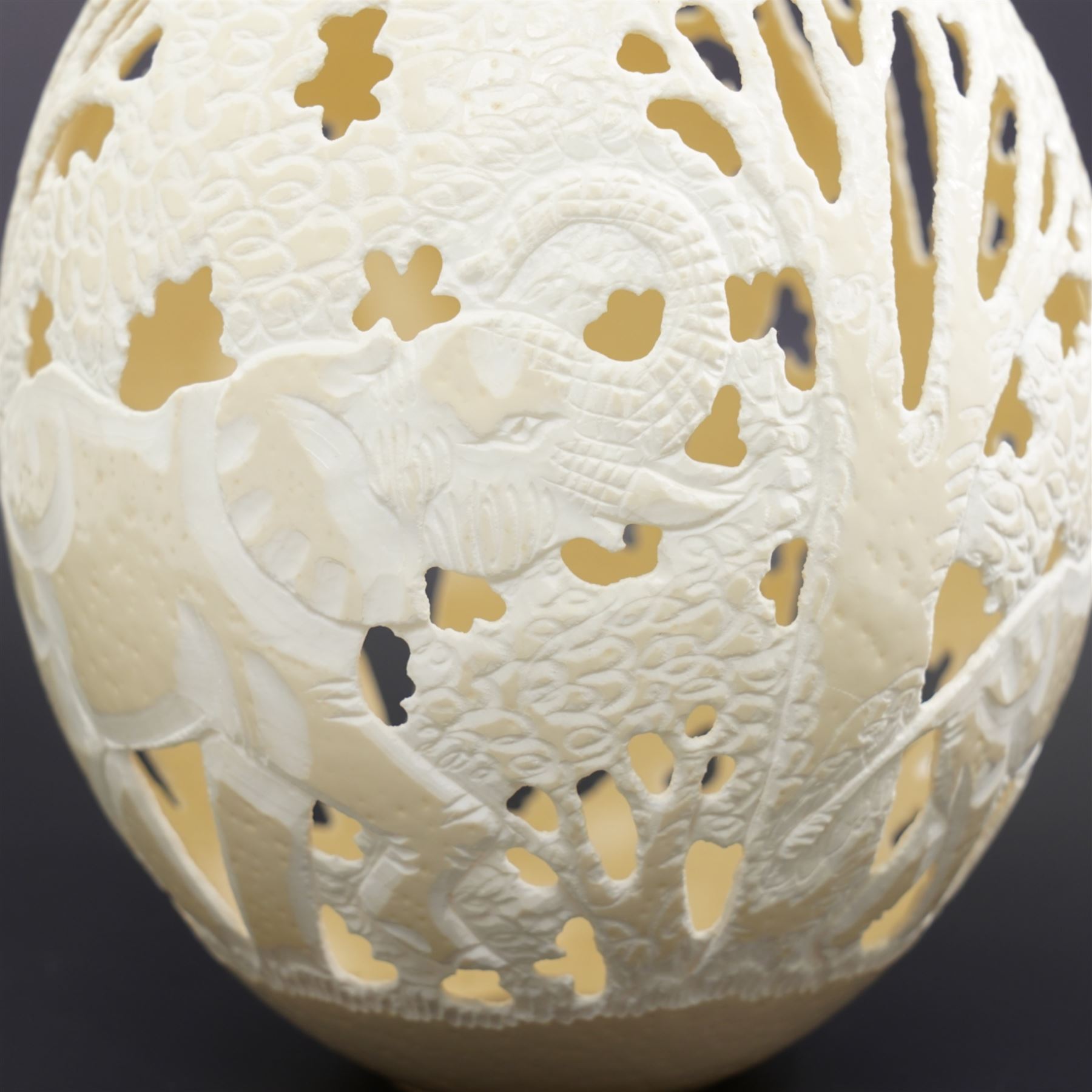 Ostrich egg with pierced decoration, depicting elephants in a forest, H16cm