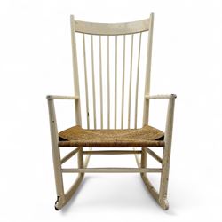 Mid-20th-century Scandinavian painted high-back rocking chair, curved top rail above slender spindle back, shaped arms with rounded ends above hand-woven rush seat, tapered rockers reinforced by turned stretchers 
