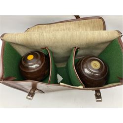 Four lignum vitae bowling woods in Slazenger carrying case