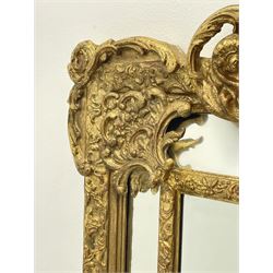 Large Victorian style gilt cushion framed mirror, putti holding urn with scrolled foliage pediment above central rectangular bevelled plate, the frame decorated with moulded foliate, each corner set with ornate cartouche