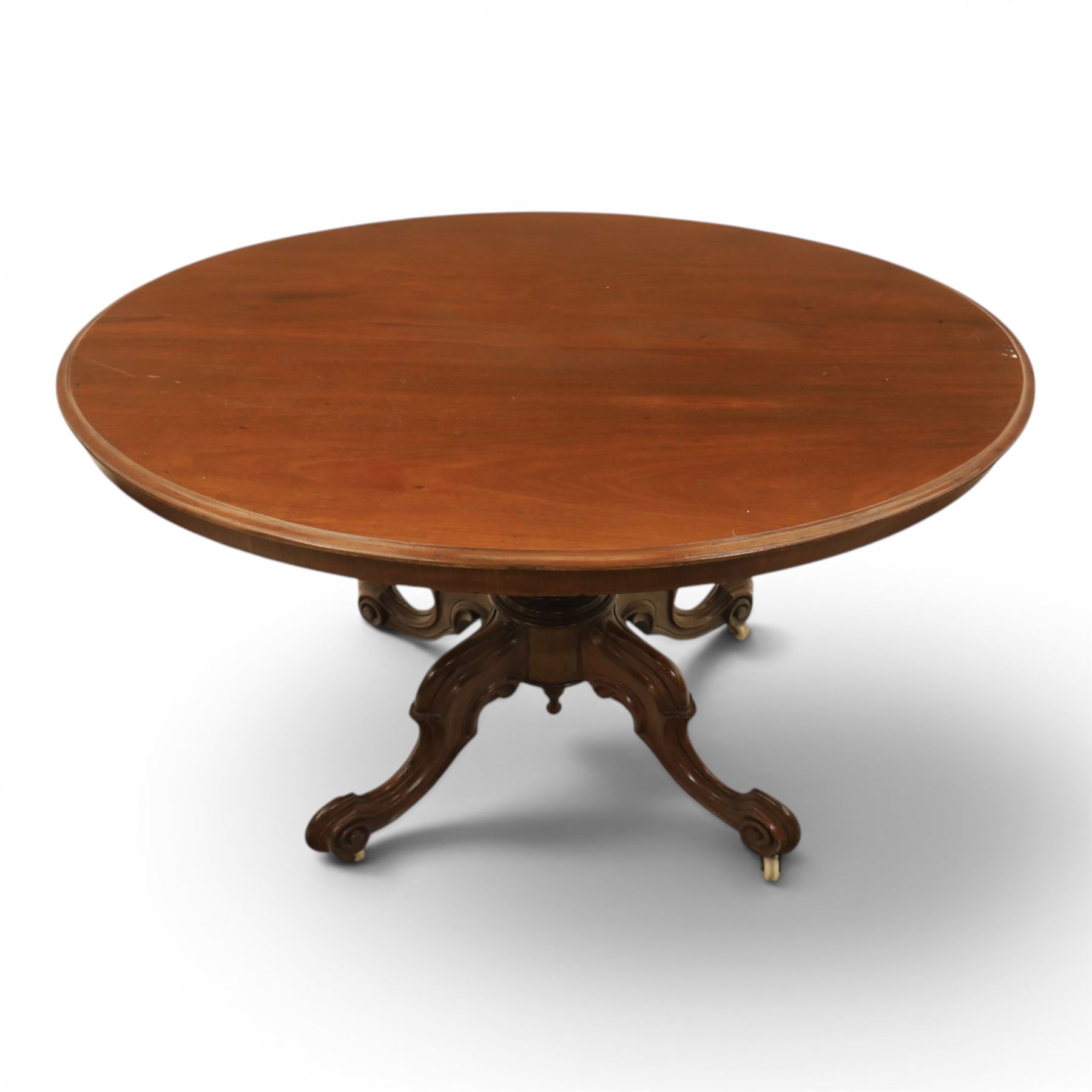 Victorian mahogany oval centre table, raised on turned column with four carved legs, ceramic castors