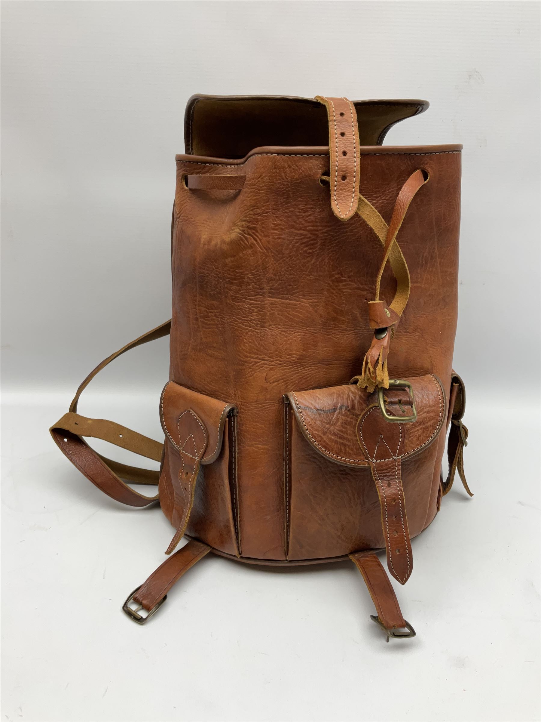 Mid-20th century plush covered teddy bear the revolving head with applied eyes, vertically stitched nose and jointed limbs with rexine pads H58cm; together with a leather backpack (2)