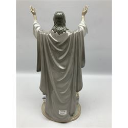 Lladro figure, The Loaves and Fishes, modelled as Jesus Christ with arms raised standing beside a basket of loaves and a basket of fish, sculpted by Salvador Furió, with original box, no 5896, year issued 1992, year retired 1997, H35cm