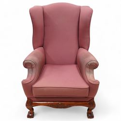 Georgian design mahogany framed wingback armchair, upholstered in rouge fabric, on ball and claw feet with foliate cartouche decoration 