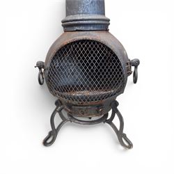 Cast iron garden chiminea, with mesh front spark guard, flue chimney on three splayed legs, finished in black.