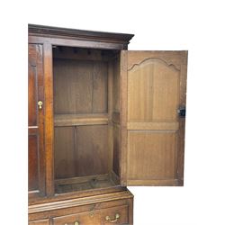 George III oak livery cupboard, projecting moulded cornice over two panelled doors, the upper panels within stepped ogee and arched moulded frame, the interior fitted with a single row of wooden hooks, two short and one long drawers, on bracket and return skirted base 