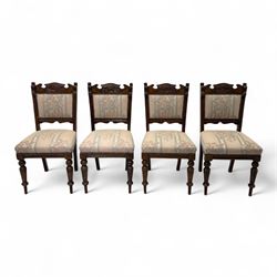 Victorian walnut set of four dining chairs, the shaped and carved top rails with central flowerhead and scroll decoration above upholstered backs and seats in floral woven fabric, brass stud trim, on ring turned front supports