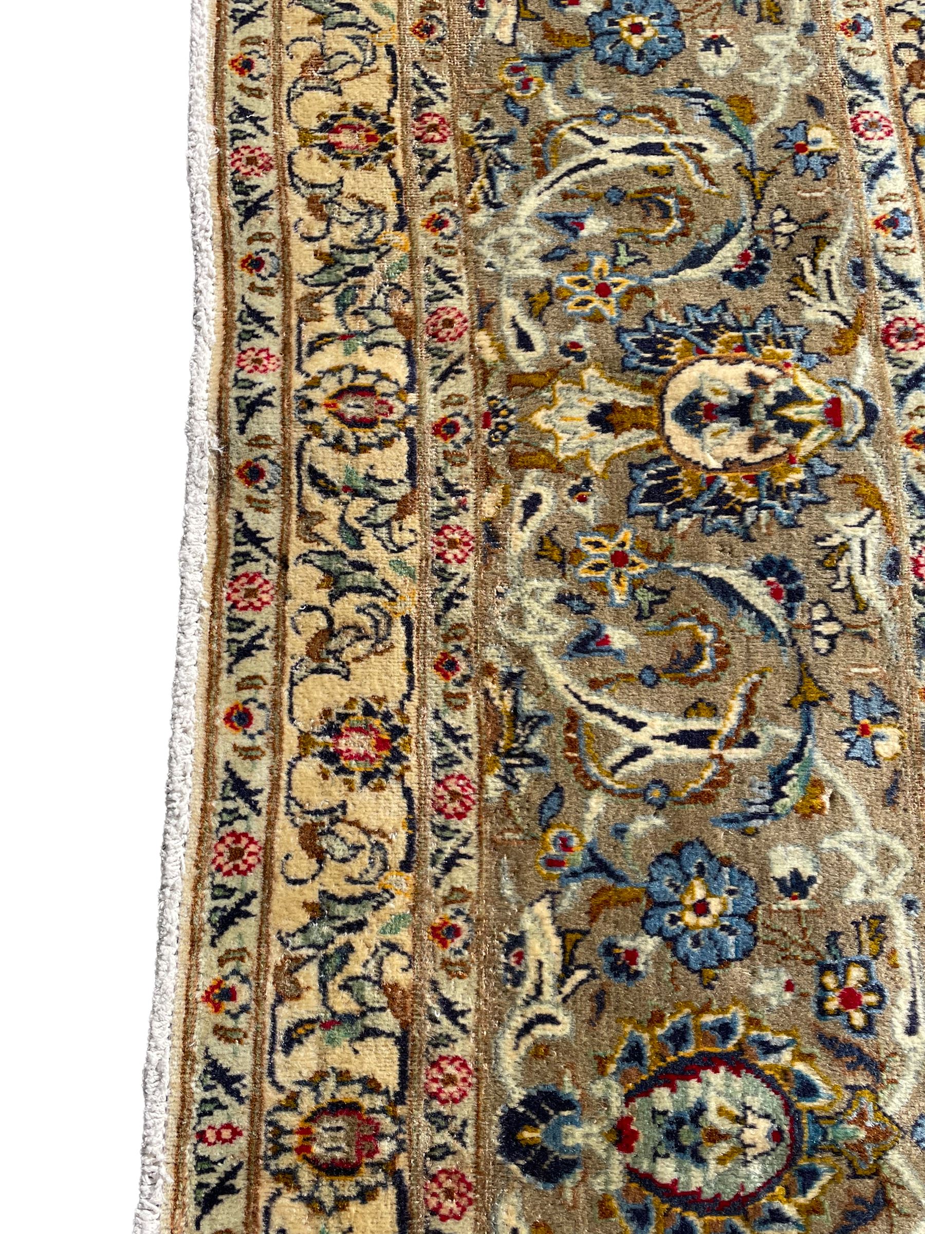 Persian Meshed carpet, ivory ground and decorated with intricate floral design with trailing scrolled branch, the central medallion decorated with stylised plant motifs, seven band border, the main band decorated with scrolls and flower head motifs