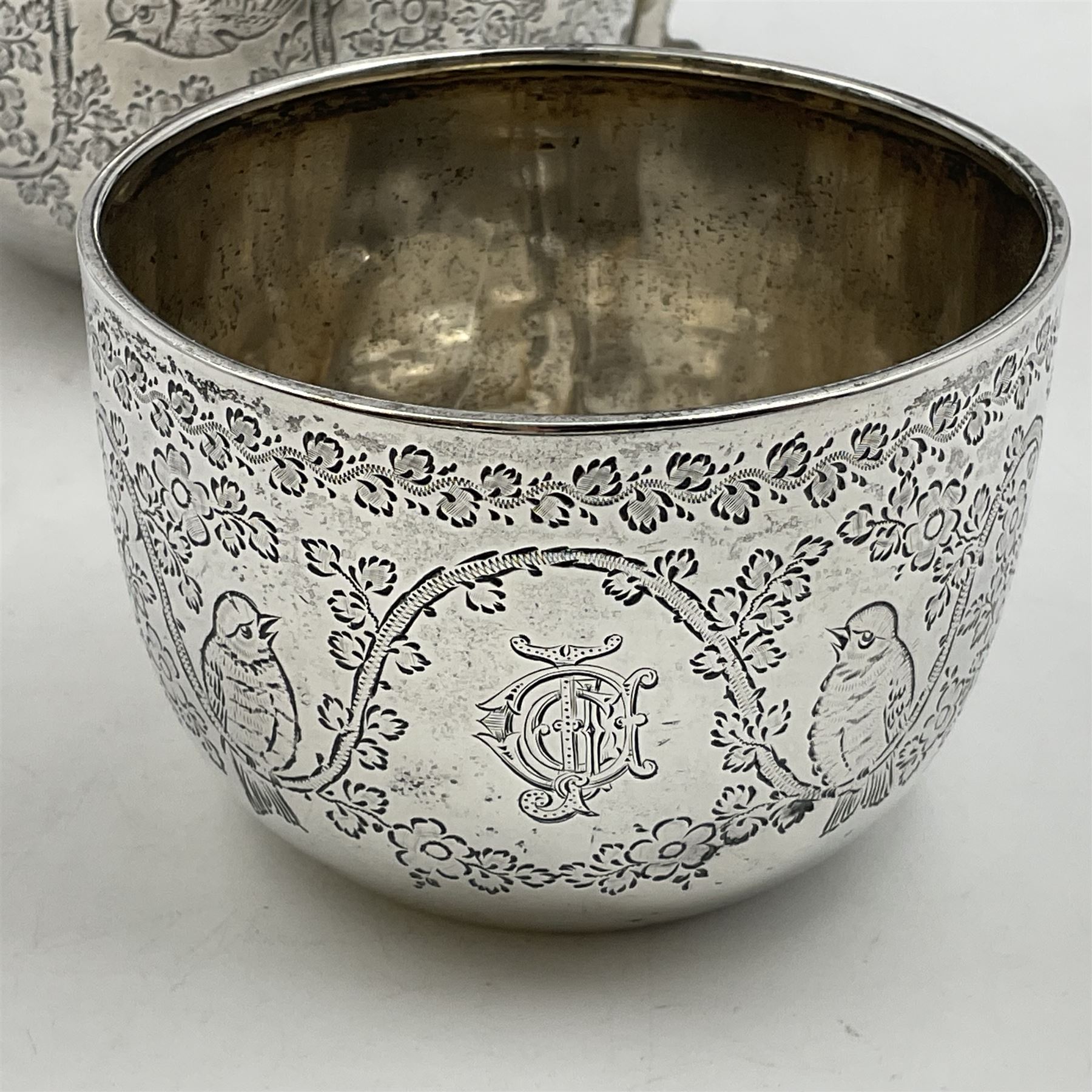 Late Victorian silver bachelors three piece tea service, comprising bullet shaped teapot, open sucrier and milk jug, each engraved with monogram surrounded by birds upon and amidst a blossoming vine, the teapot with scroll capped curved wooden handle and wooden finial to cover, hallmarked Wakely & Wheeler, London 1890, teapot including handle H12cm, sucrier H5.5cm 