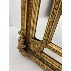 Gilt Rococo style mirror, arched top with central cartouche and oak leaf moulded pediment, floral and fruit moulded surround with segmented glass panels, bevelled central pane, c-scroll shell and acanthus leaf brackets