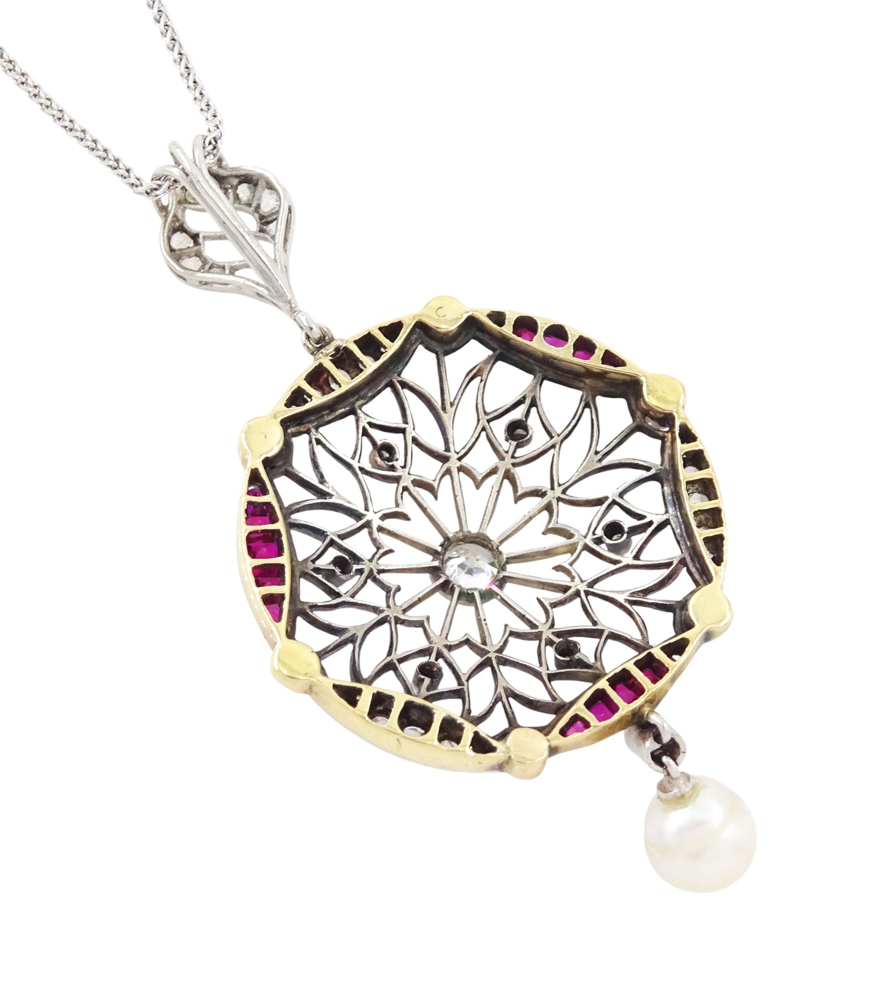 Early 20th century platinum and 18ct yellow gold ruby and diamond circular pendant, single old cut diamond of approx 0.25 carat, within a milgrain pierced fancy foliate surround, set with single cut diamonds, to a navette shaped border set with alternate calibre cut rubies and rose cut diamonds, each spaced by a single old cut diamond, suspending a pearl and diamond drop, on a later 18ct white gold wheat link chain necklace, hallmarked