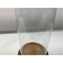 Glass dome display covers on a circular wooden base, H46cm