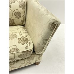 Knole ‘Snuggler’ drop arm sofa upholstered in pale fabric with raised floral pattern, with scatter cushions 