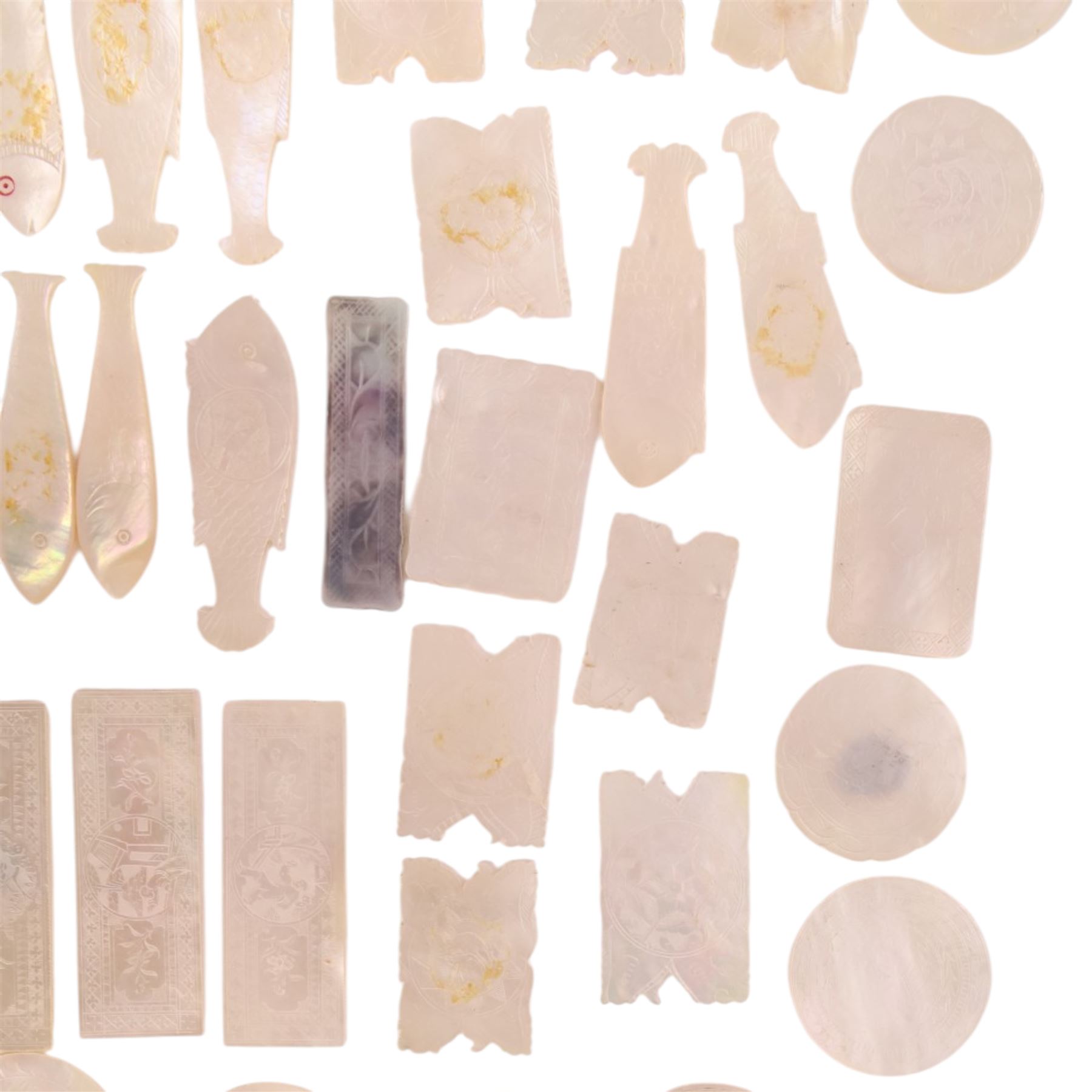 Collection of approximately sixty mother-of-pearl gaming tokens, including fish-shaped, rectangular, circular examples 