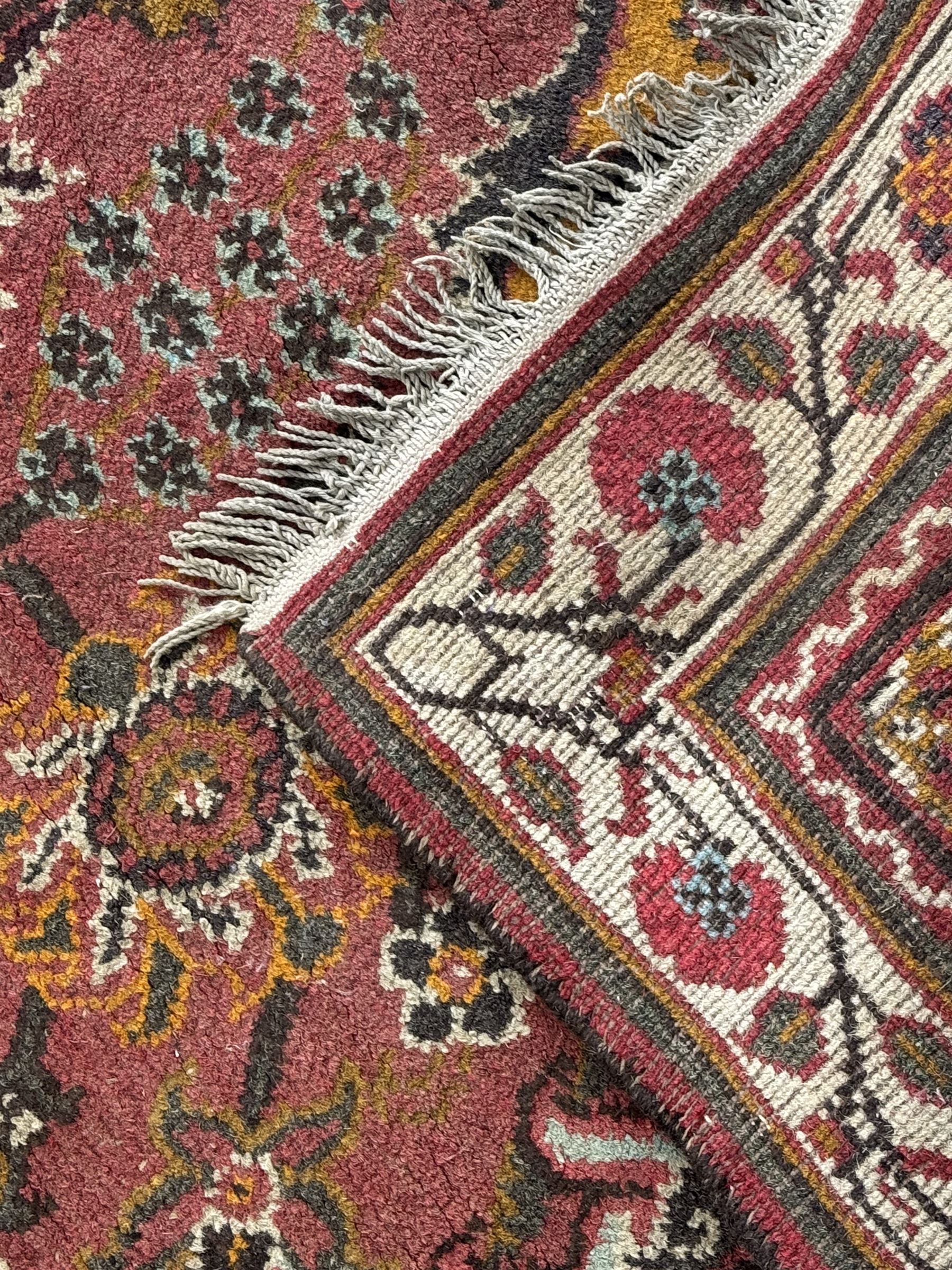 Belgian Sultan woollen ground rug, central navy field densely decorated with floral sprays and geometric patterns (192cm x 135cm); handwoven tribal terracotta ground rug (121cm x 71cm); Persian crimson ground runner, all over stylised floral and foliate motifs (266cm x 94cm)