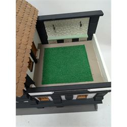 1:24 scale four-storey tudor-style dolls house, with black and white exterior, balcony garden, glazed panelled windows and wooden shingle roof, with decorated interior and wired fireplaces and lighting, H65cm, W58cm, D31cm, 