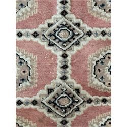 Persian design pale pink ground rug, the field divided into panels and decorated with Gul motifs, wide multi-band border with geometric patterns 