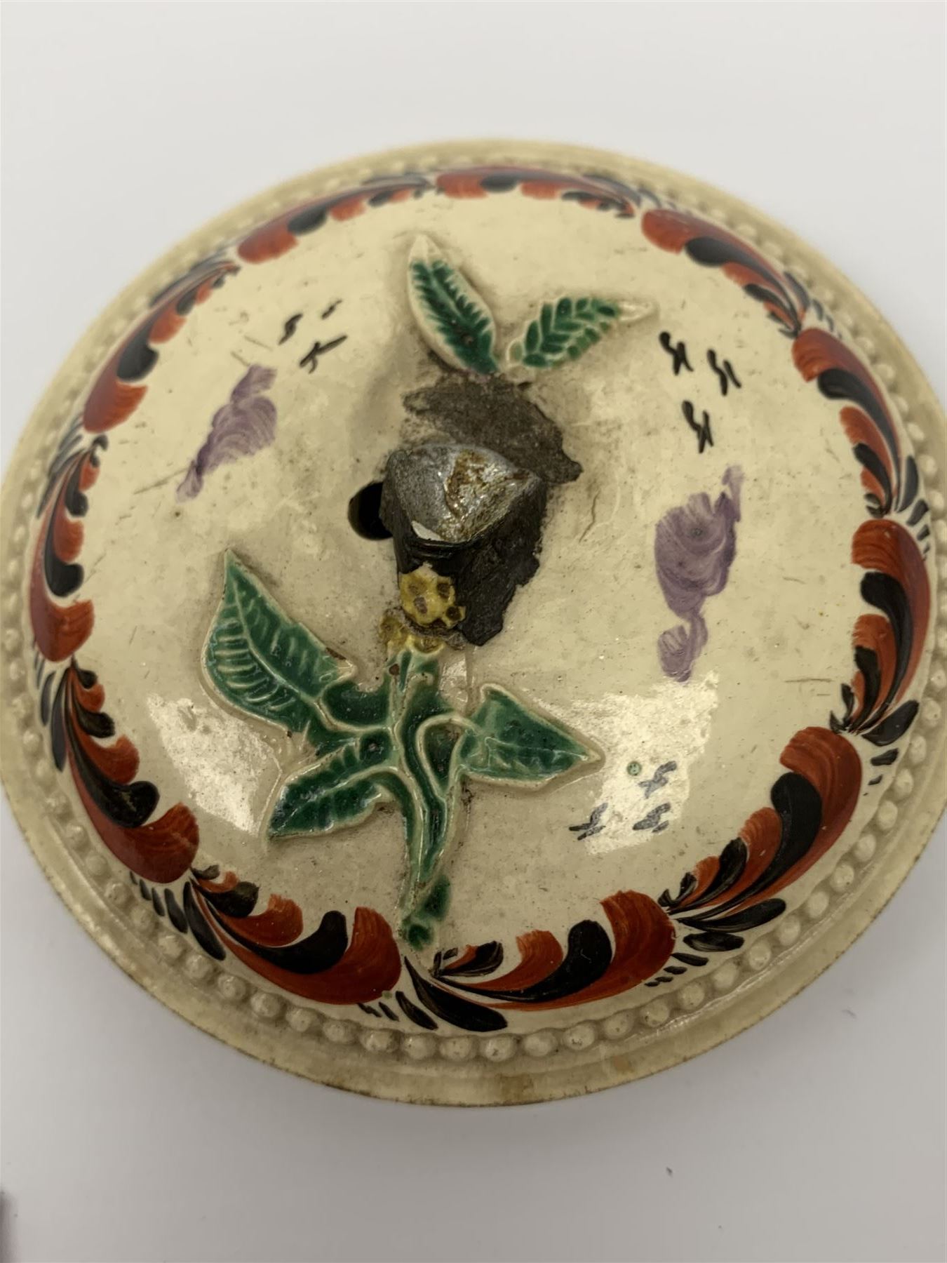 18th century creamware teapot, probably Leeds, with reeded entwined handle and floral finial to the cover, the body with hand painted polychrome decoration of figure to one side, and floral spray to the other, collectors paper label beneath inscribed Leeds Pottery, H11.5cm