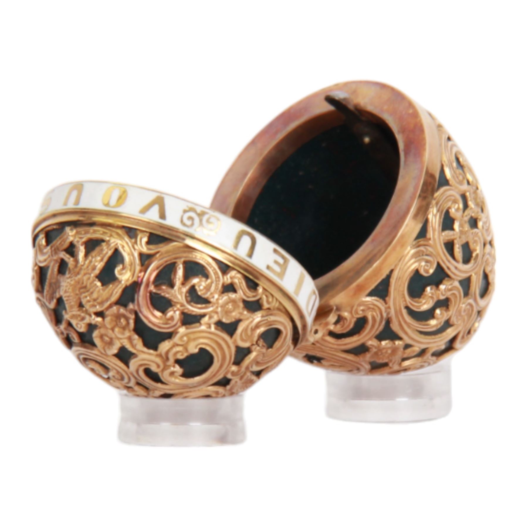 Late 18th/early 19th century gold mounted bloodstone bonbonniere in the form of an egg, unmarked, French or English, with gold overlaid C scroll, foliate and bird detailed cagework, the hinged cover with white enamelled band detailed 'Dieu Vous Benit' (God Bless You), opening with a rose cut diamond push thumbpiece, H4.5cm

Cf. Comparable examples sold at auction:
Lot 284, Objects of Vertu, Dix Noonan Webb, 14th September 2021
Lot 1643, Fine Jewellery, Wolley & Wallis, 27th April 2017
