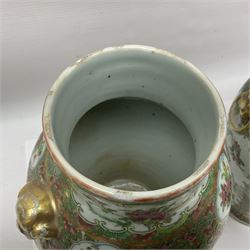 Pair of 19th century Chinese Famille Rose vases and covers, each of baluster form with twin gilt lion mask ring handles to shoulders, the flattened domed covers with gilt temple lion finials, each decorated with alternating reserves of bijin and attendants, and birds and butterflies amongst blossoming peonies, against a gilt ground profusely decorated with stylised scrolls, H32.5cm