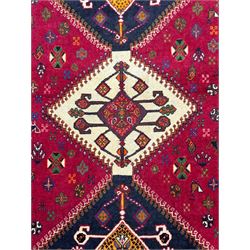 South West Persian Qashqai red ground runner, the crimson field decorated with three connected lozenges, surrounded by small stylised motifs of bird and plants, indigo spandrels with further stylised motifs, the border with repeating floral design 