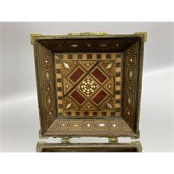 Late 19th century Damascus Cairoware Quran box, of square form with canted hinged cover, upon four circular pad feet, the brass exterior inlaid with silver and copper script and decorative detail, opening to reveal a marquetry lined interior, H15.5cm W19cm D19cm