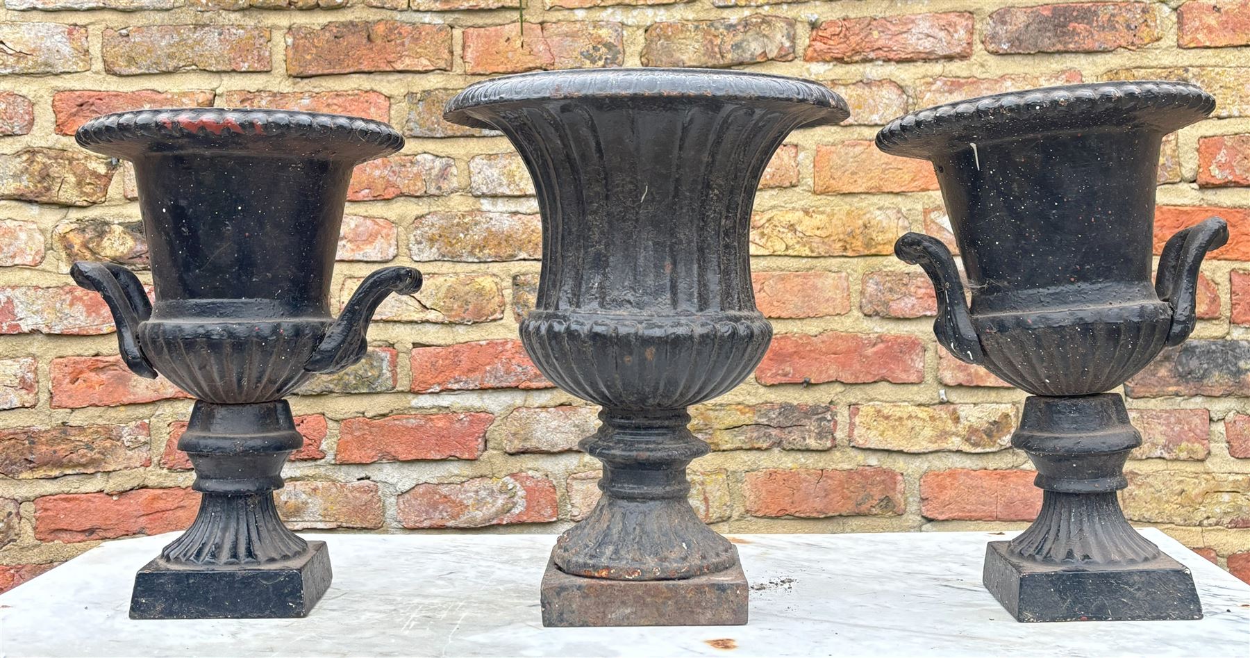 Pair of Victorian style cast iron urns of characteristic form (H35cm) together with another (H37cm) (3)  - COLLECTION BY APPOINTMENT FROM: The White House, Thirsk Road, Easingwold, York, YO61 3NF - CALL 01723 507111 TO ARRANGE