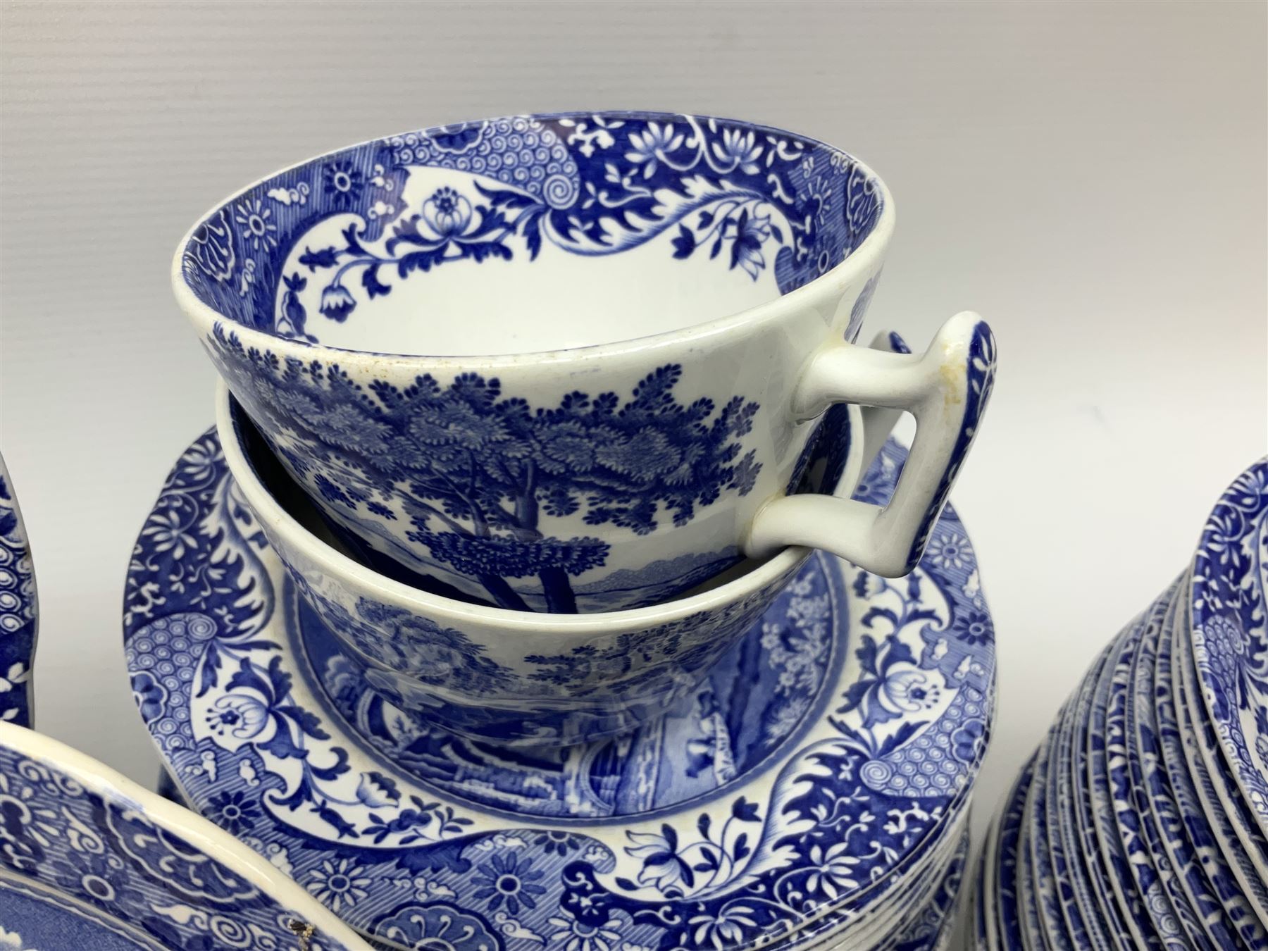 Spode blue and white Italian pattern dinner and tea wares, comprising five dinner plates, four side plates, seventeen side plates, four bowls, ten tea cups and twenty one saucers, five coffee cans and six saucers, and a flan dish, with blue and black printed marks beneath 